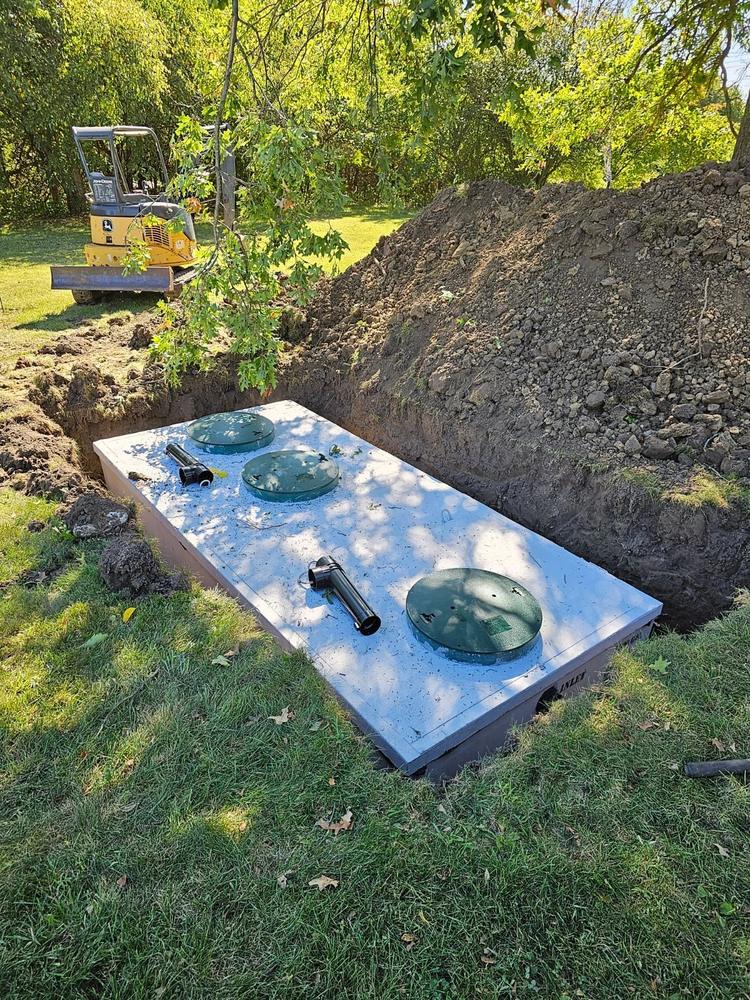 Newly set concrete septic tank with risers and lids